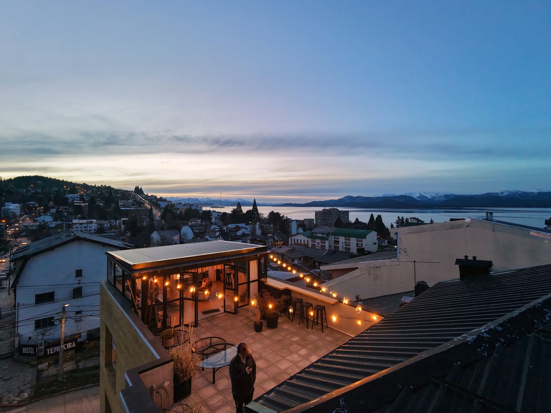 La terraza de Piu Avanti al atardecer, con el Nahuel Huapi de fondo